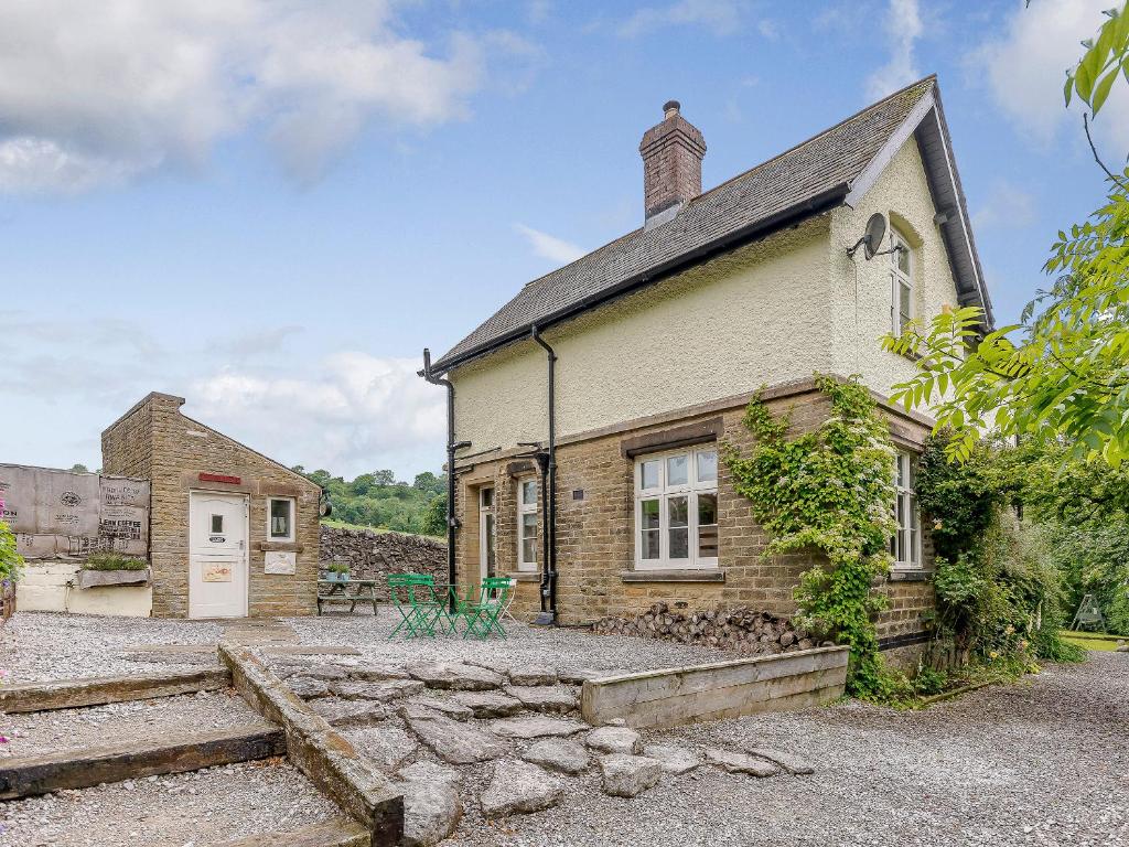 an old brick house with a stone courtyard outside at Station House in Millers Dale