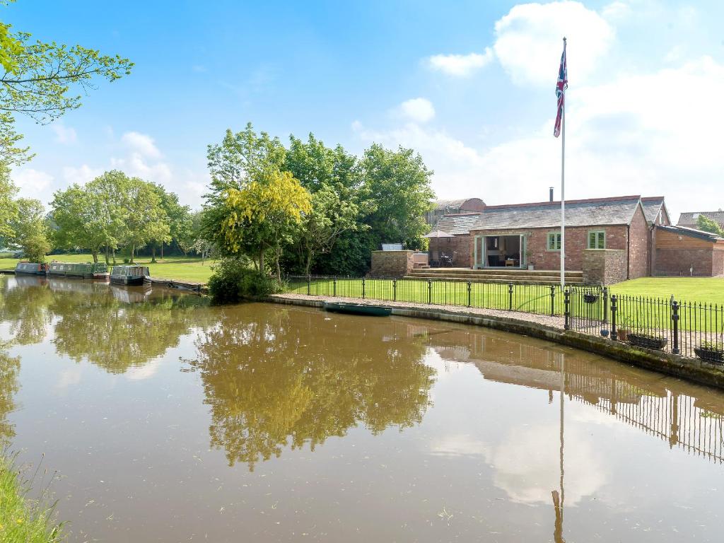 a river in front of a building with a flag at Canal View in Ellesmere