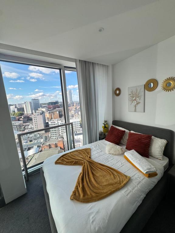 Un dormitorio con una cama grande con una ventana grande. en Luxurious Rotunda City View Apartment in Birmingham City Centre, en Birmingham