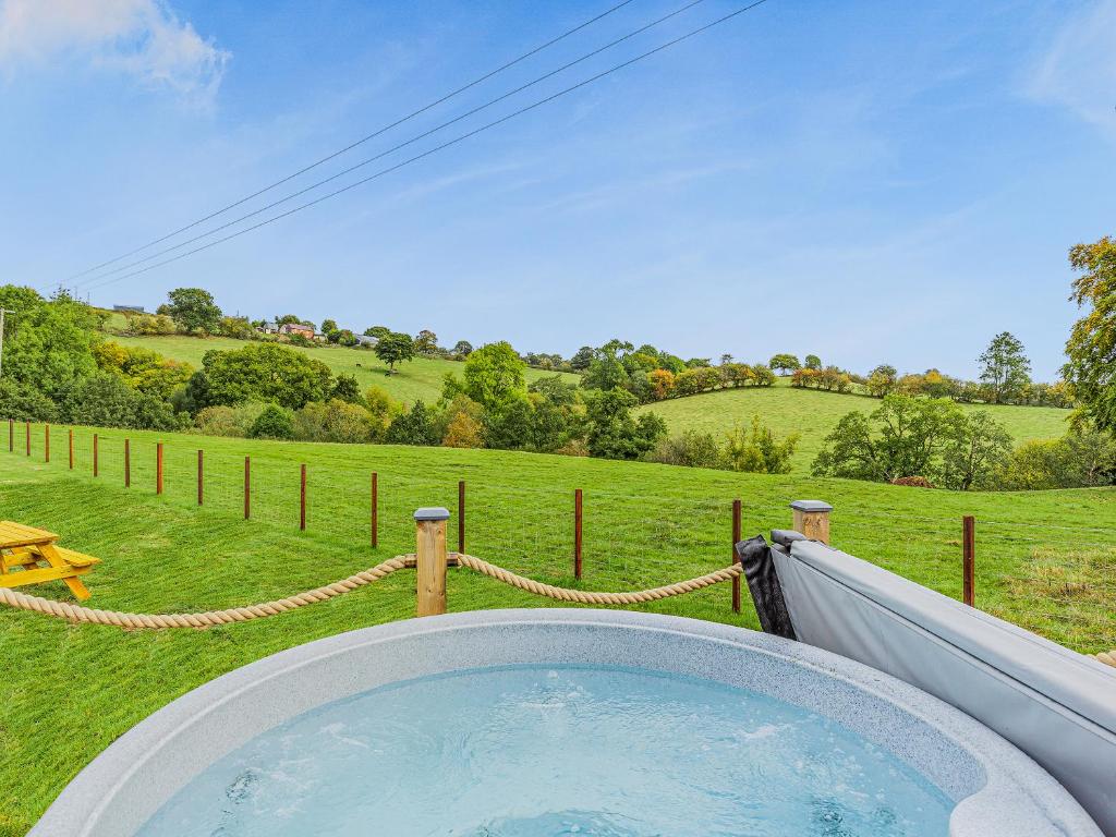 una bañera de hidromasaje en medio de un campo en Oak-Uk36258, en Llanfair Caereinion