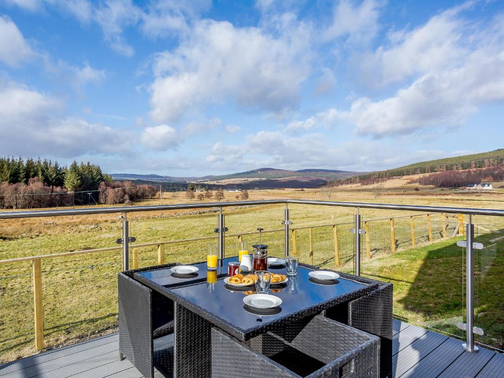 un tavolo su una terrazza con vista su un campo di Knocknahighle a Cromdale
