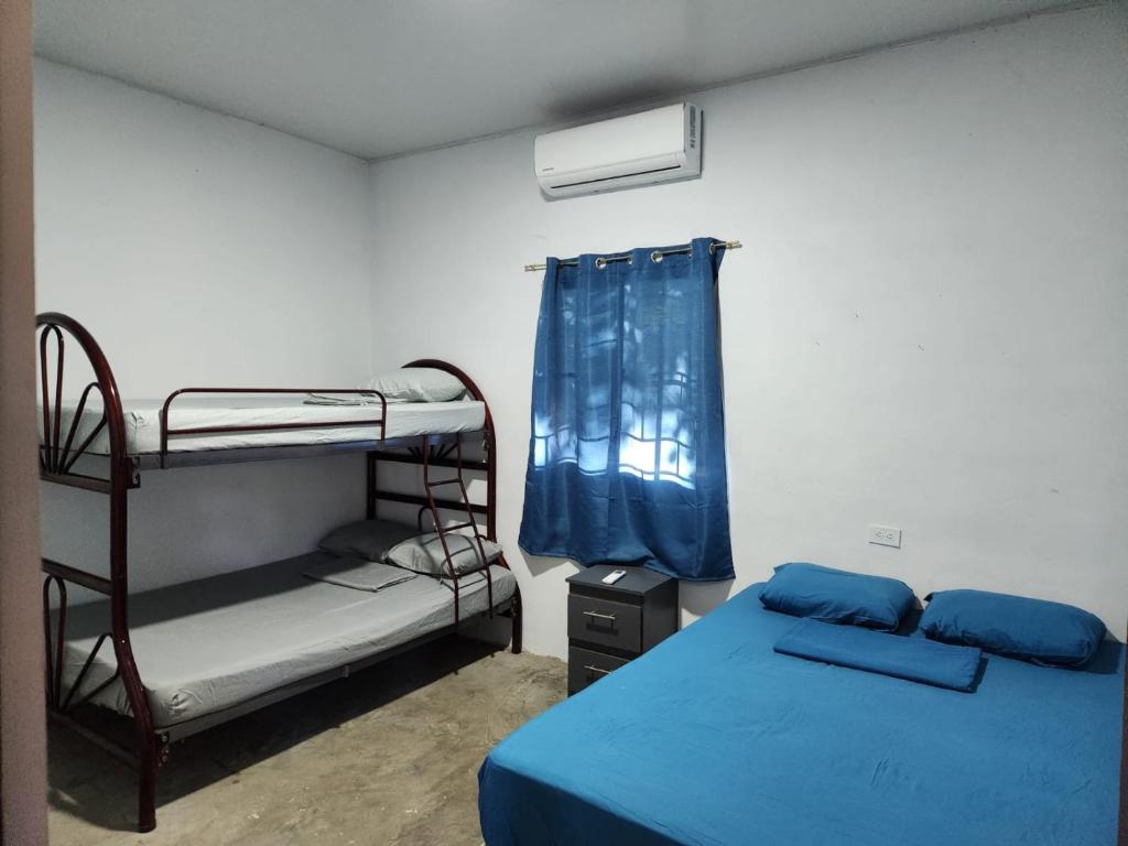 1 Schlafzimmer mit 2 Etagenbetten und einem blauen Bett in der Unterkunft 6 Caracoles in Cangrejera