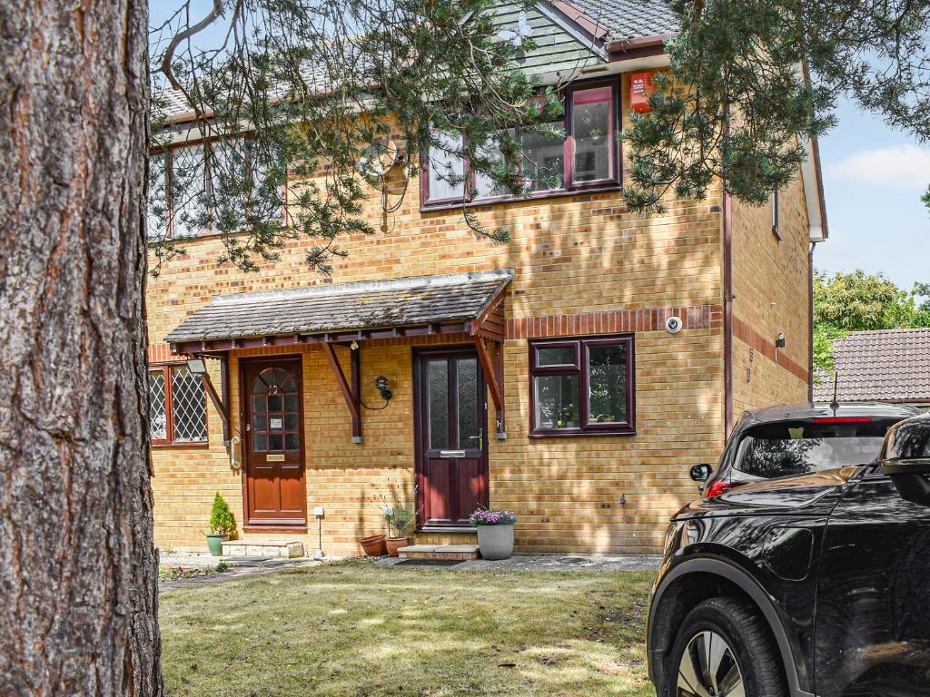 a brick house with a car parked in front of it at Chestnut House in Wareham