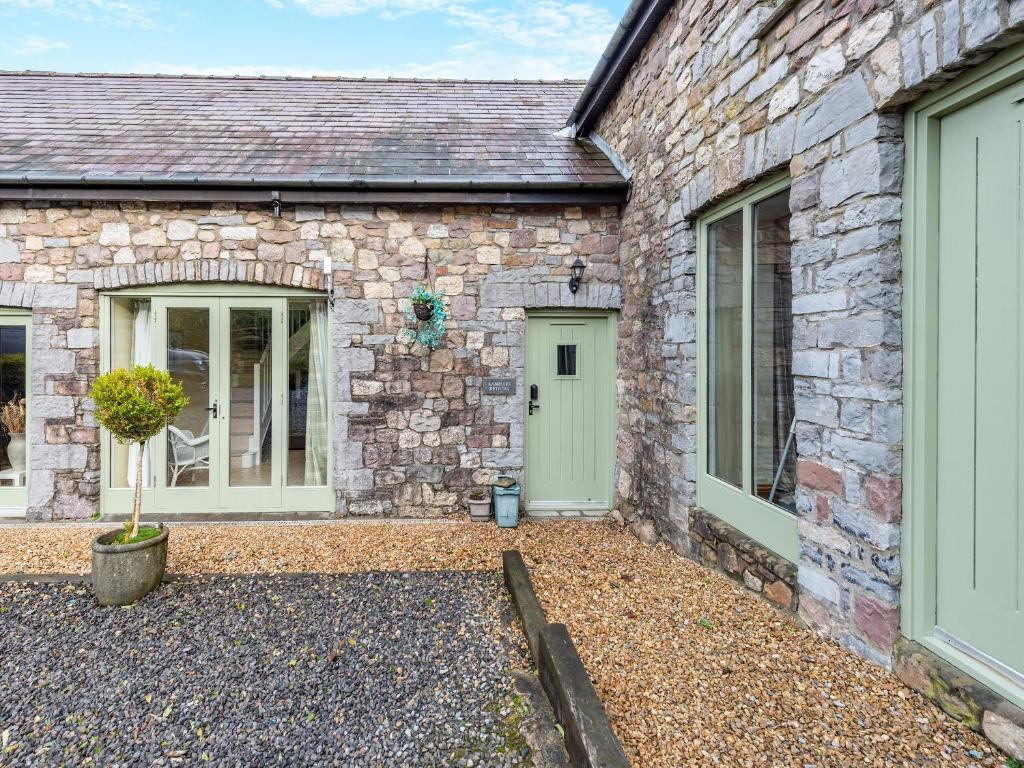 a stone house with two doors and a courtyard at Ramblers Retreat - Uk48386 in Llangadog
