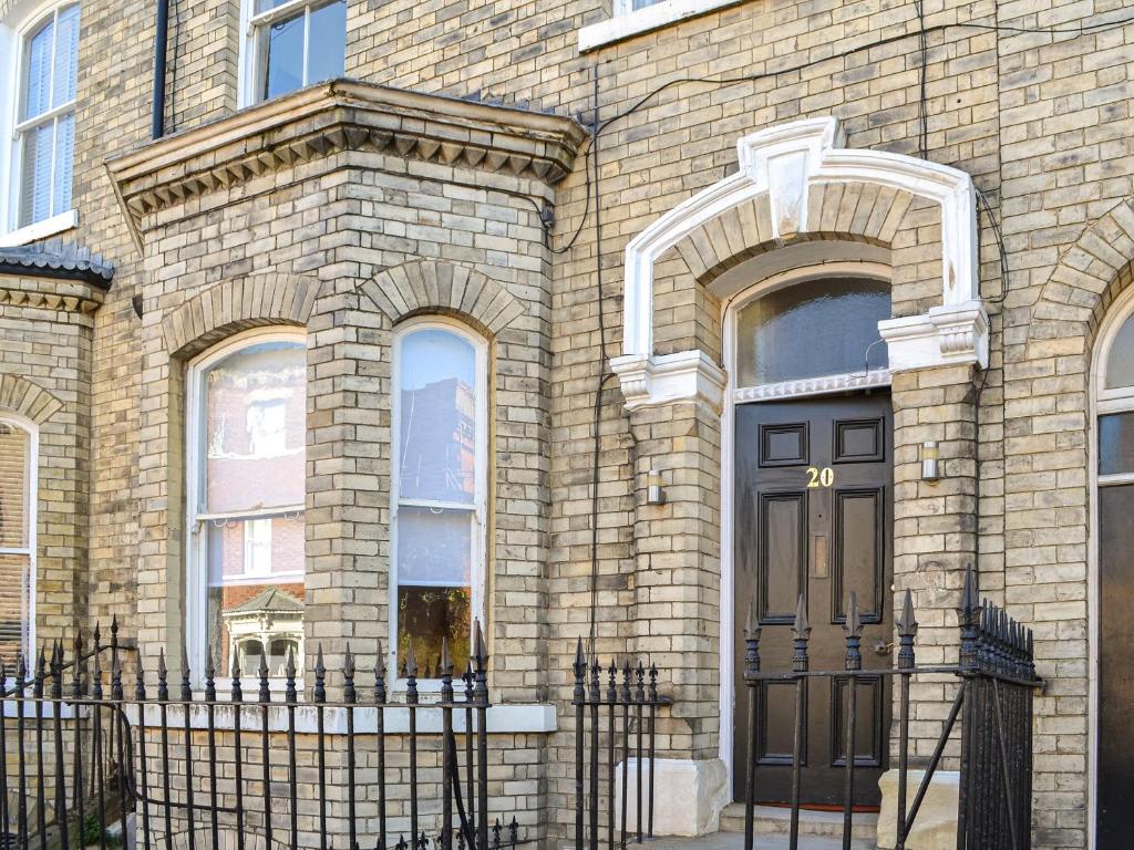a brick building with a black door and a fence at The Wharfe - Flat 1 - Uk49411 in York