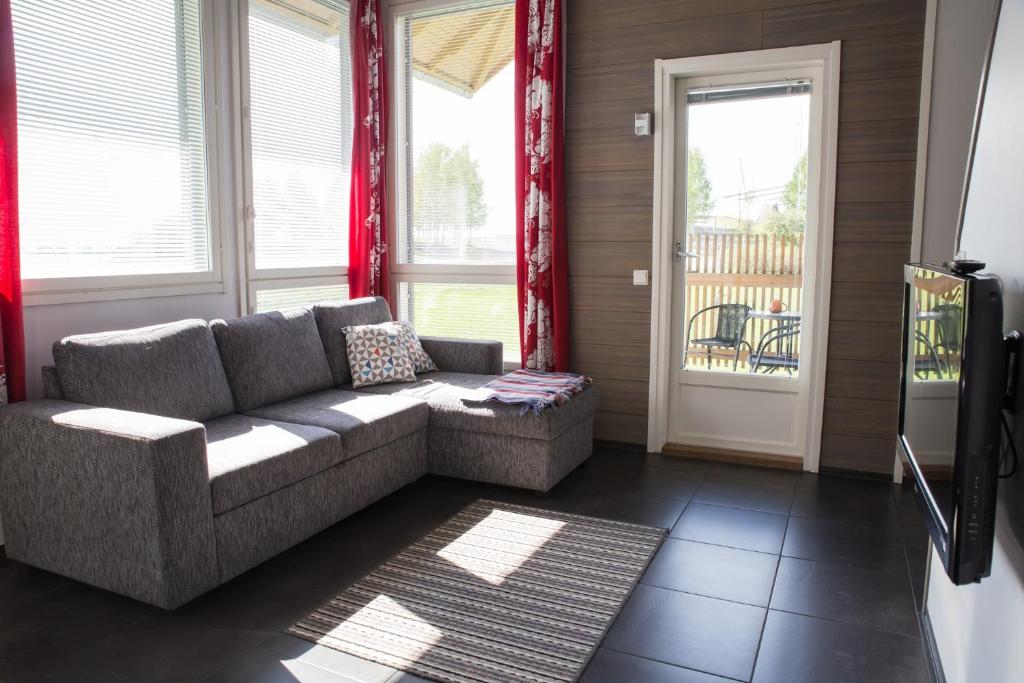 a living room with a couch and a window at Holiday Linnunlahti in Joensuu