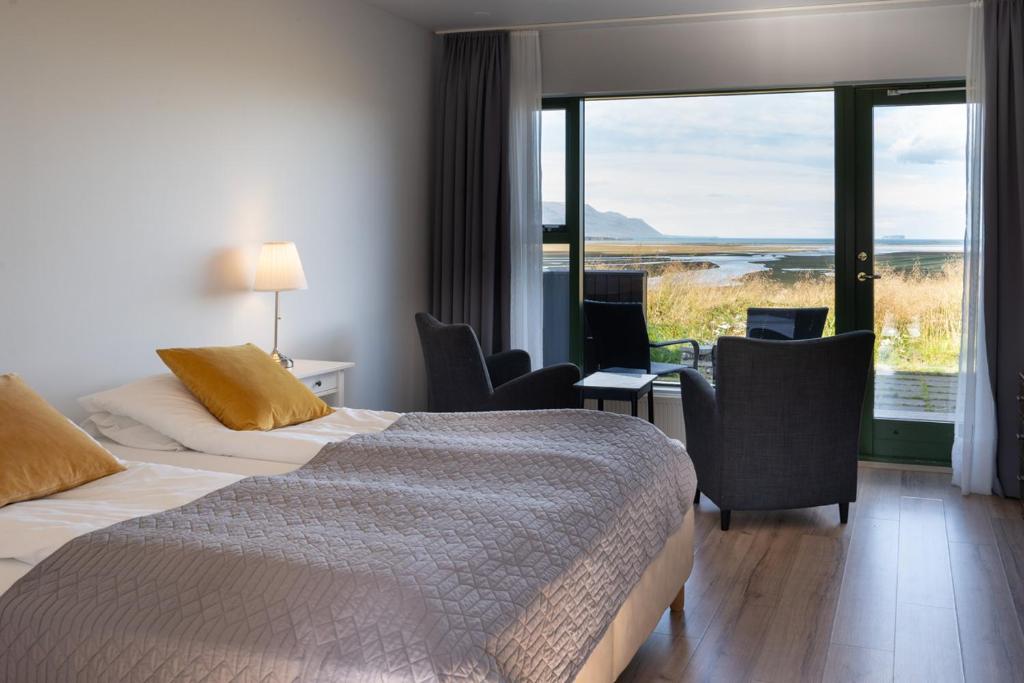 a hotel room with a bed and a desk and a window at Hofsstadir - Country Hotel in Hofstaðir