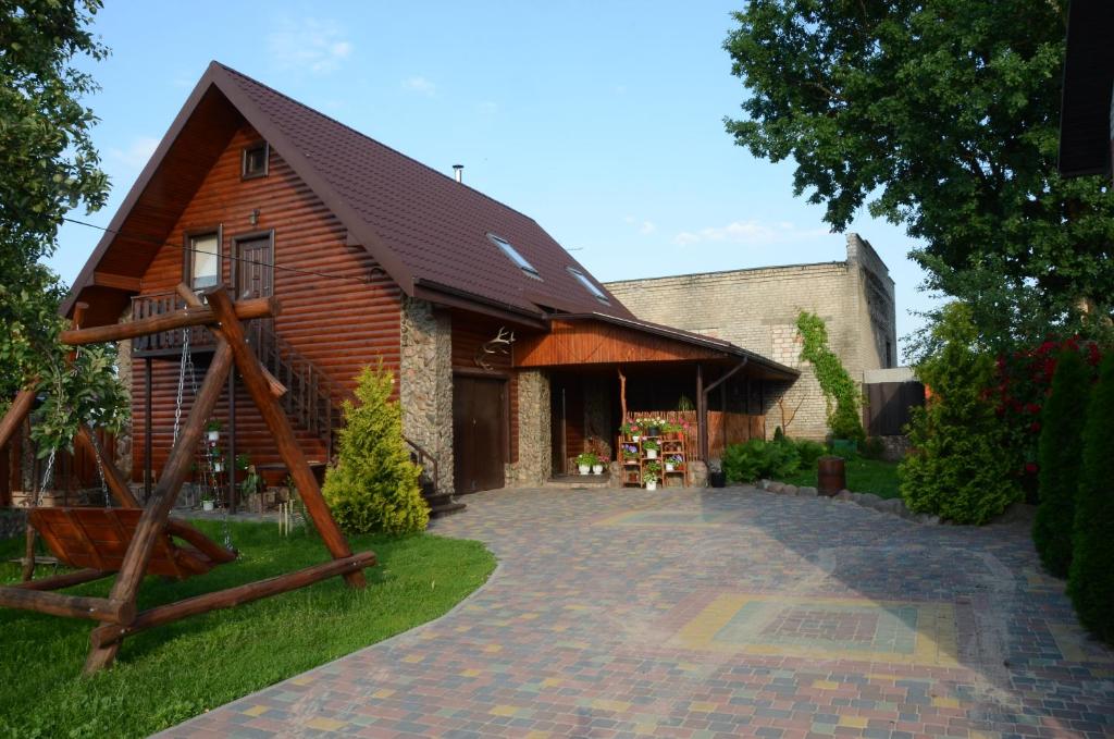 a barn with a gambrel roof and a brick driveway at Agrousadba Kamenetskoye Zatishye in Kamenets