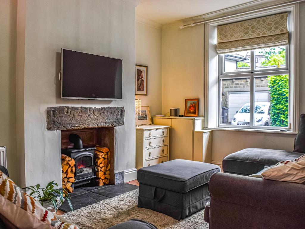 a living room with a fireplace and a television at Cooperative Cottage - Uk44502 in Saddleworth