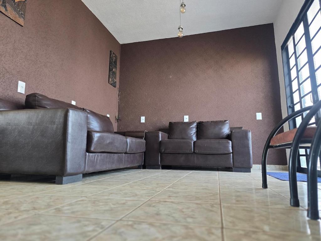 a living room with two leather couches against a wall at Mirage grand vista in Franca