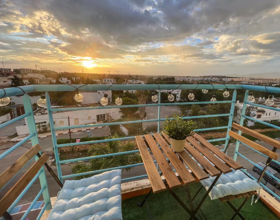 a table and chairs on a balcony with a sunset at Buenavista CaboNegro in Cabo Negro