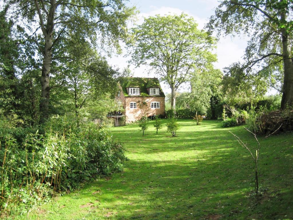 an old house in the middle of a field at The Mill in Lindridge