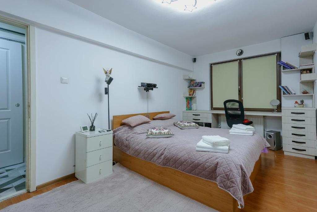 a bedroom with a bed with a dresser and a desk at Good Vibes Studio in Bistriţa