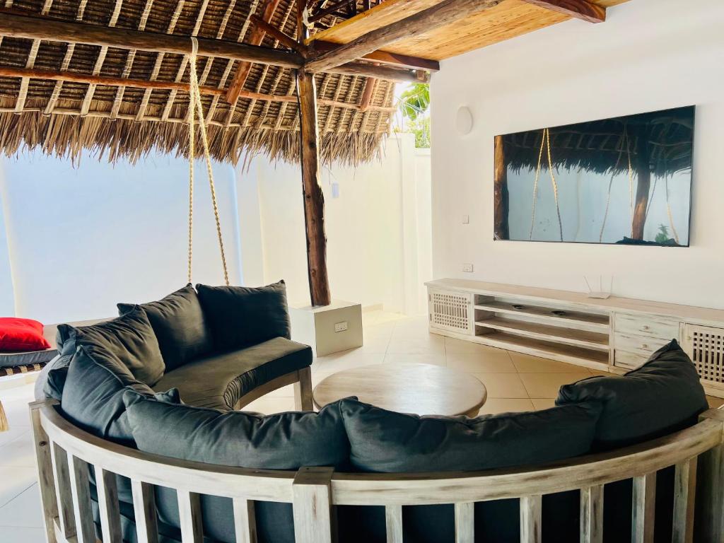 a living room with a couch and a tv at Jumeirah Malindi Hotel in Malindi