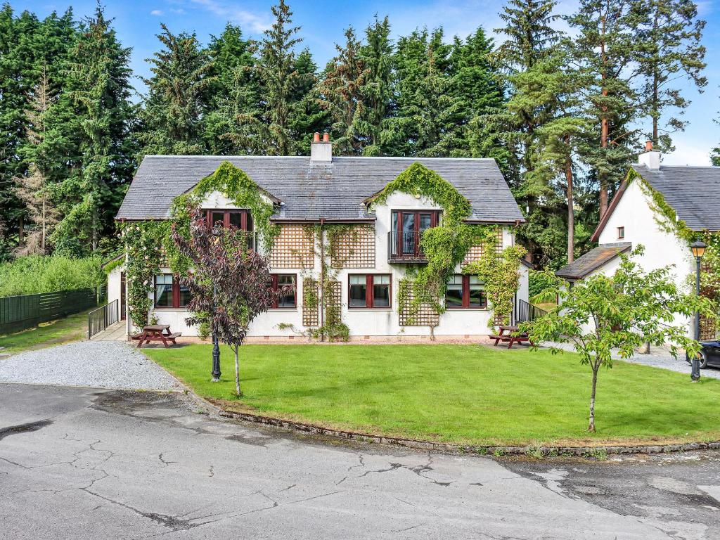 a house with a yard with grass and trees at Family Lodge No 2 The Place Downstairs - Uk45691 in Pitlochry