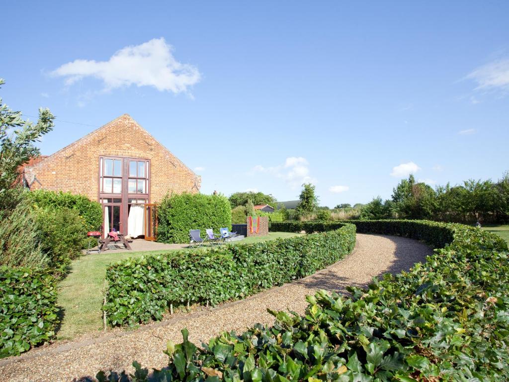 a path in a garden with a house in the background at Bay - E4482 in Ludham