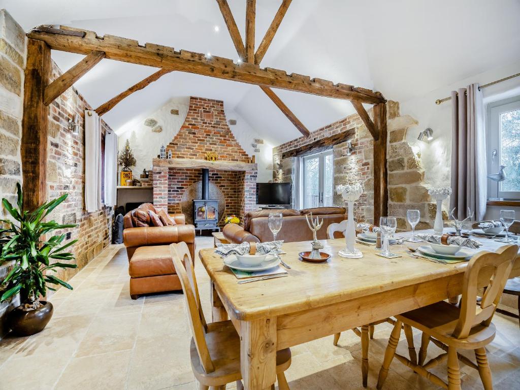 una sala da pranzo con tavolo in legno e camino di The Old Granary a Cumberworth