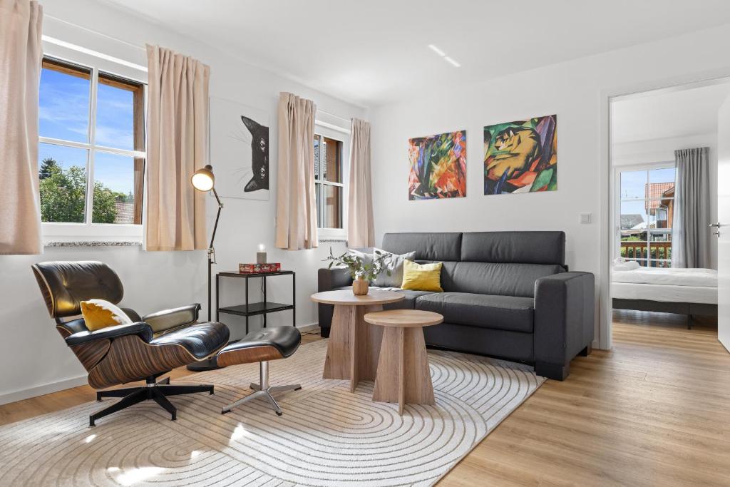 un salon avec un canapé et une table dans l'établissement BALANCED Münsing Apartments, vollausgestatte Ferienwohnungen Nähe Starnberger See, à Münsing