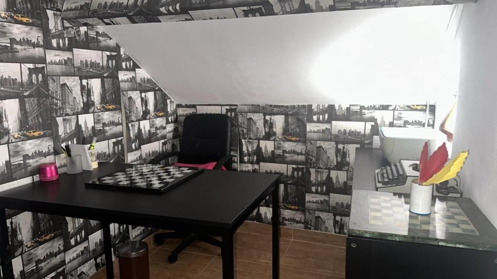 Una habitación con una mesa y una pared de fotos. en Cantinho Cartaxo, en Cartaxo