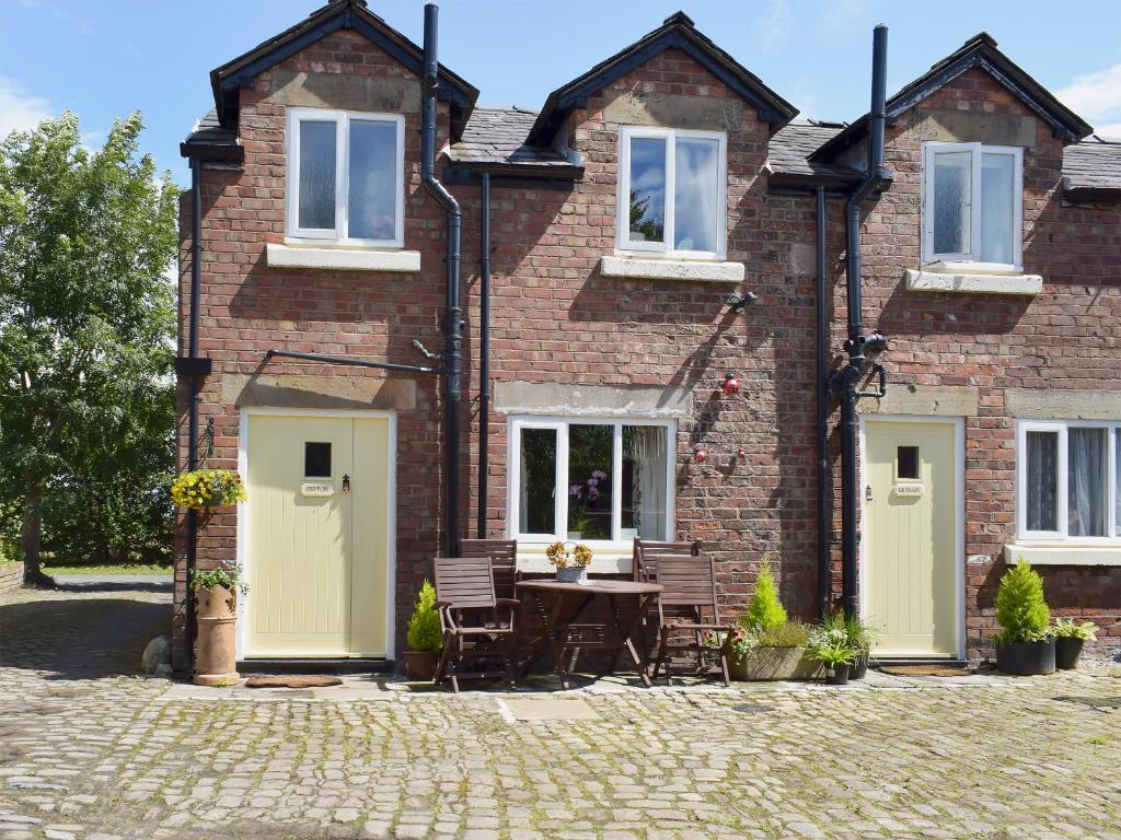 a brick house with a table in front of it at The Shippon in Burscough