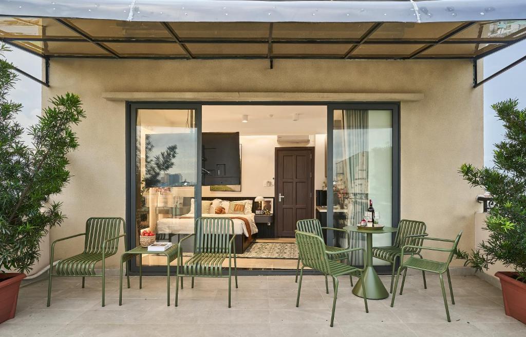 a patio with chairs and a table and a bedroom at Secret Garden Hotel Bình Thạnh in Ho Chi Minh City
