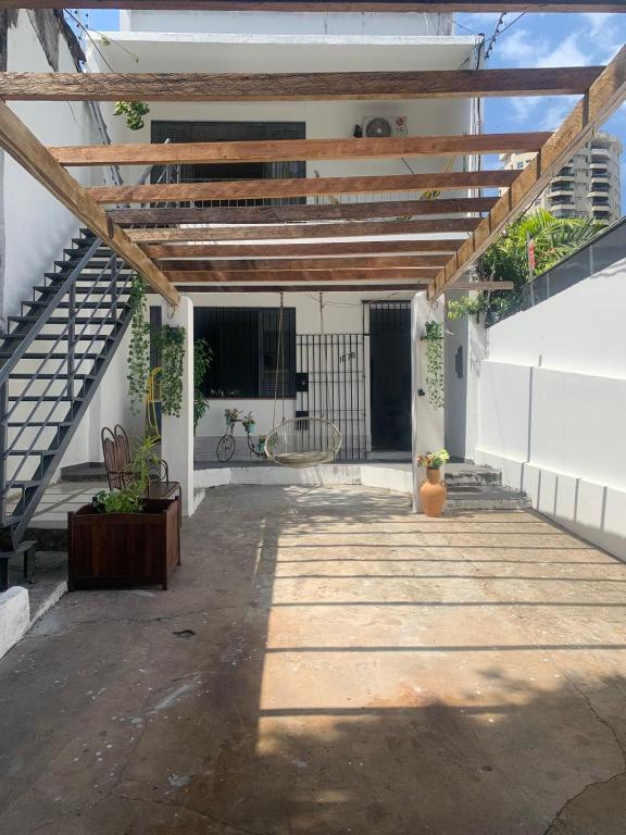an outdoor patio with a wooden pergola at Quarto em casa arborizada in Belém