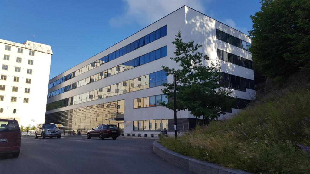 un gran edificio con coches estacionados frente a él en Hotel Montebello, en Oslo