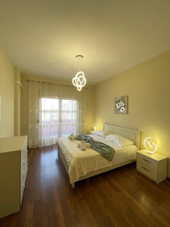 ein Schlafzimmer mit einem Bett und einem Kronleuchter in der Unterkunft Shkodra Central Corner in Shkodra
