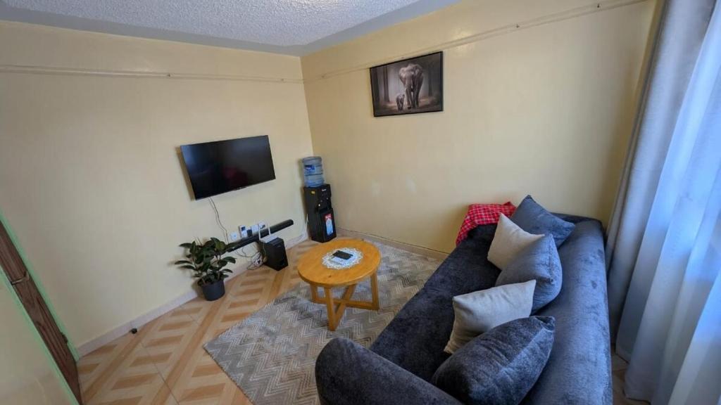 a living room with a blue couch and a table at The Loch in Naivasha