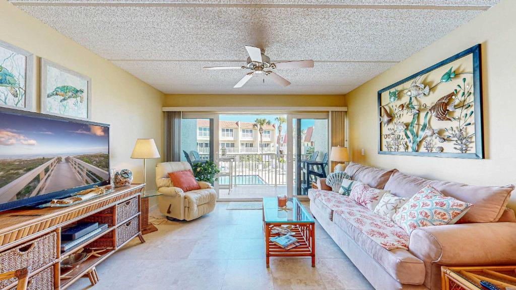 Una sala de estar con un sofá y un televisor de pantalla plana. en Pier Point Ocean View Unit D-52, en St. Augustine Beach