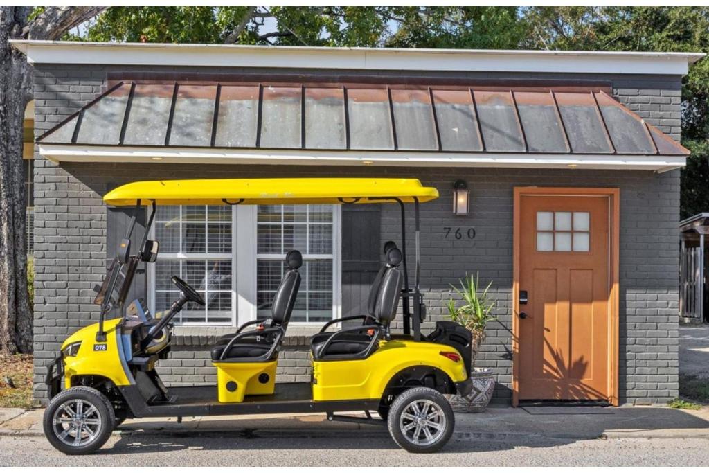 a yellow golf cart parked in front of a house at Water Street Retreat Walk To Casinos, Restaurants in Biloxi