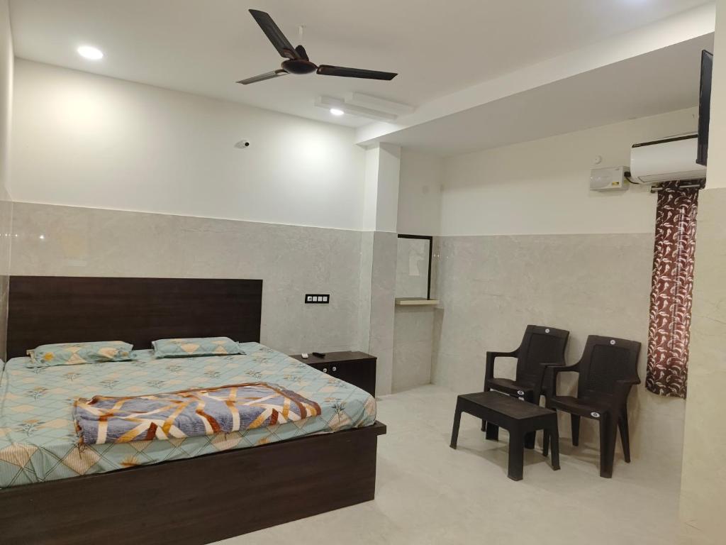 a bedroom with a bed and a ceiling fan at SWASTIK STAY Ac and Non Ac Rooms in Raigīr