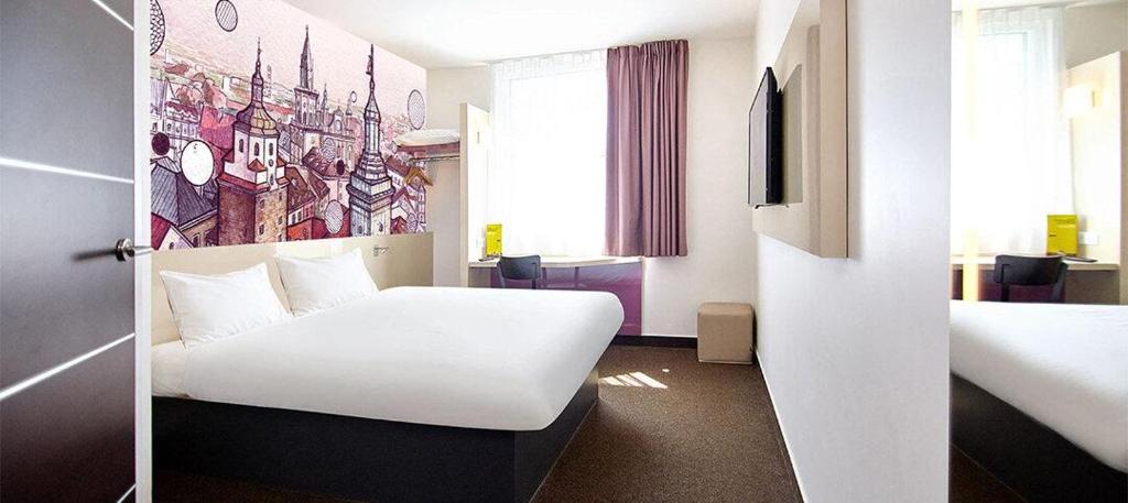 una habitación de hotel con una cama blanca y una habitación con en B&amp;B Hotel Lublin Centrum, en Lublin