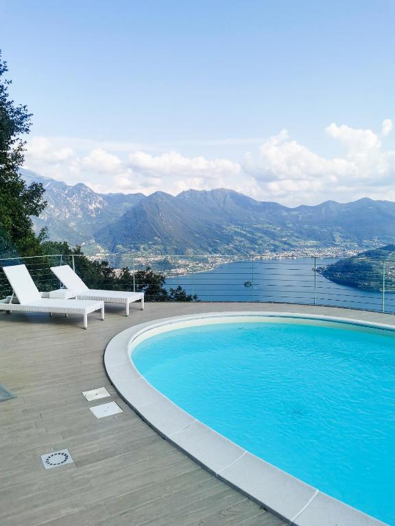 a swimming pool with chairs and a view of the water at Casa Raki in Parzanica