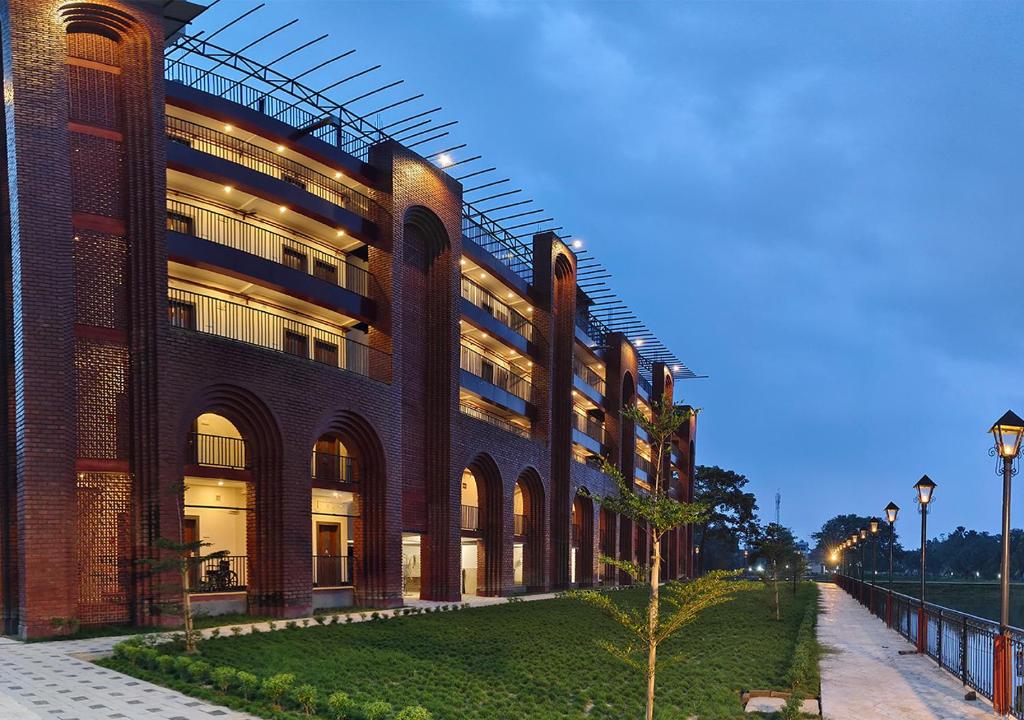 a large brick building with a tree in front of it at MAHFIL-e-MOTIJHEEL, MOTIJHEEL PARK AND RESORT in Lālbāgh