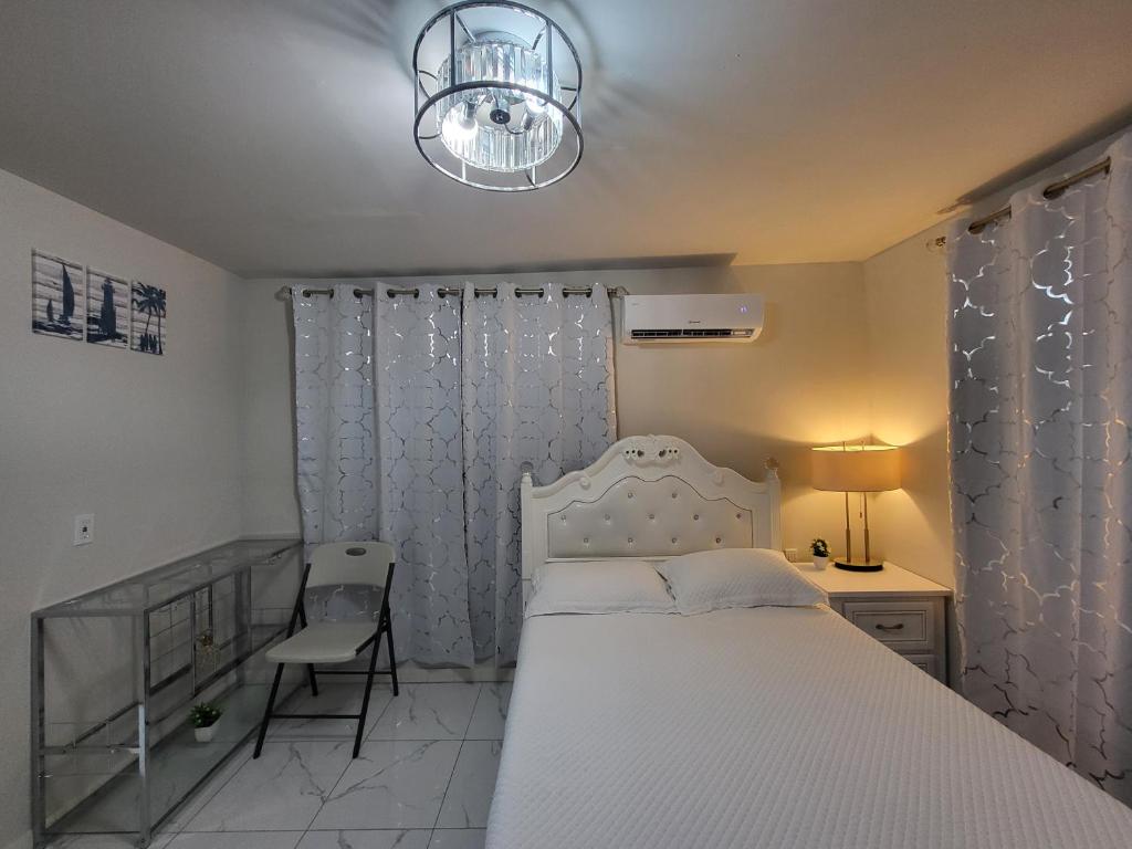 une chambre avec un lit blanc et une chaise dans l'établissement Paseo Miami, à Miami