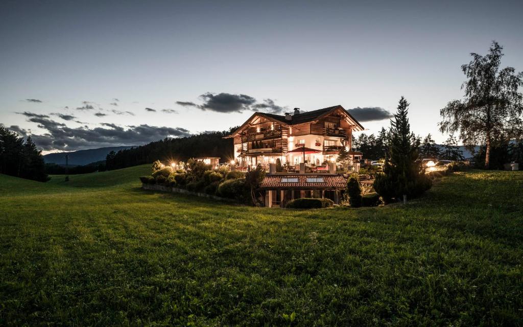 a large house in a field with lights at Alpine Boutique Villa Gabriela - Adults Only in Castelrotto