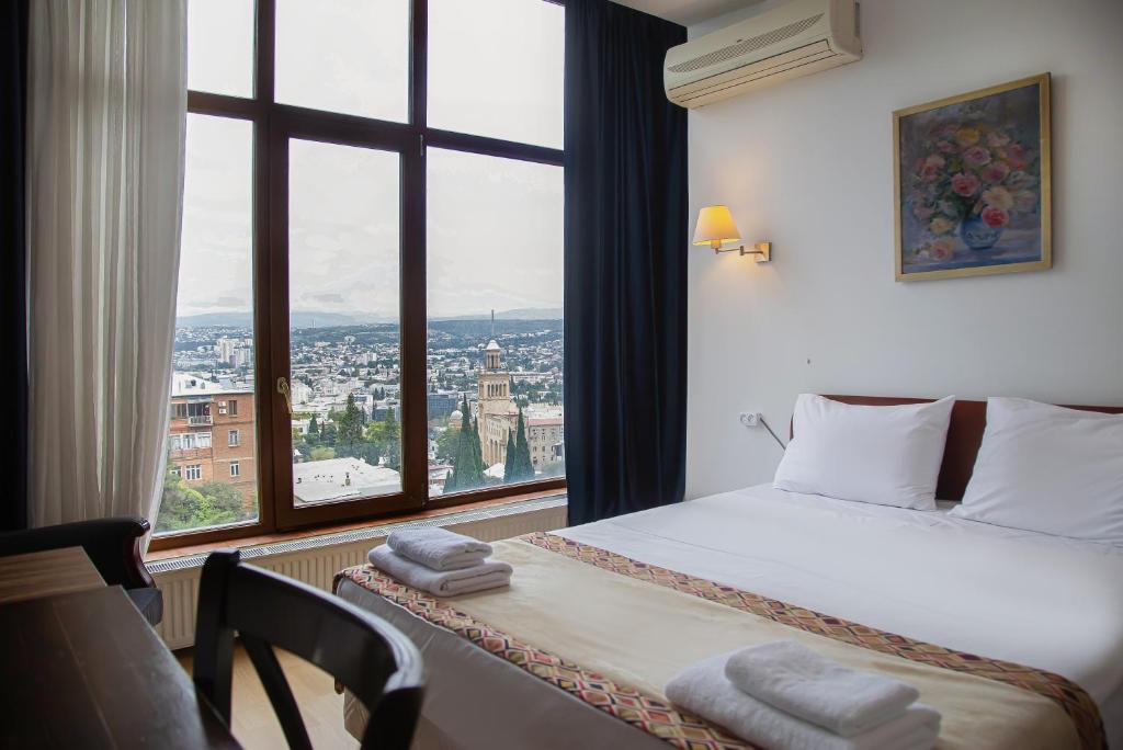 a hotel room with a bed and a large window at Boutique Hotel "Andza Tiflis" in Tbilisi City