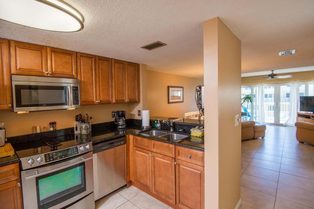 a kitchen with wooden cabinets and stainless steel appliances at Pier Point South Ocean View Townhouse Condo B-20 in Saint Augustine Beach