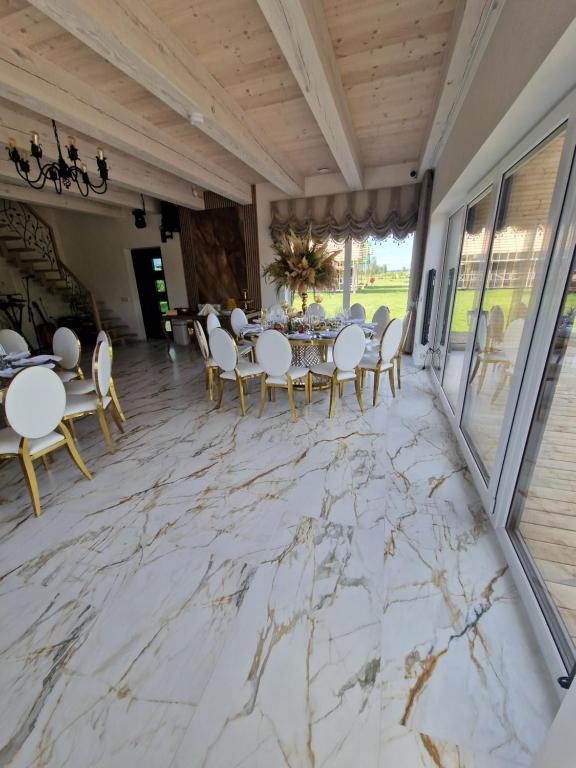 a dining room with a marble floor and a table and chairs at Baltasis beržas 