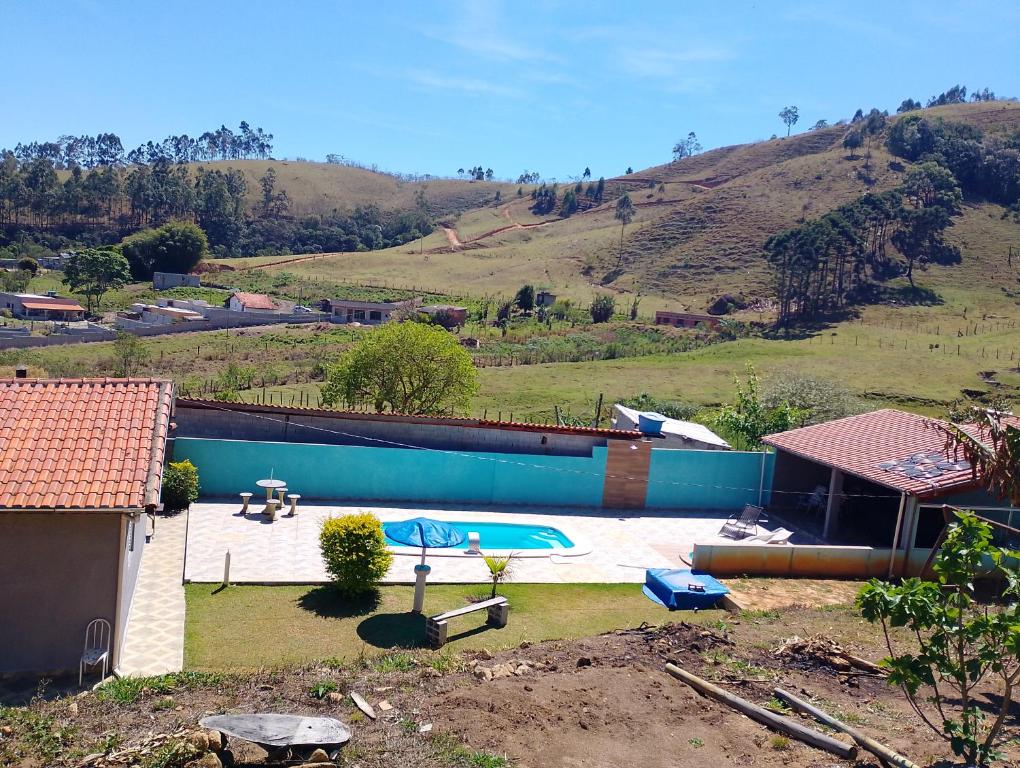 a backyard with a swimming pool and a hill at Casa de Campo Chácara Cantinho dos Sonhos in Extrema