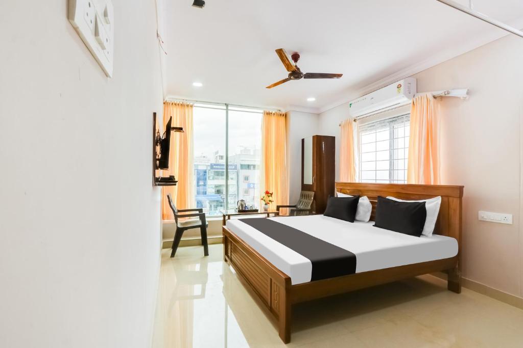 a bedroom with a bed and a desk and a window at Hotel O S P R Luxury Rooms in Hyderabad