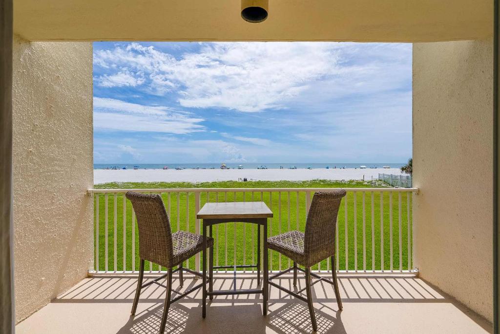 d'un balcon avec deux chaises et une table et vue sur l'océan. dans l'établissement Pier Point South Oceanfront Townhouse Condo E-60, à Saint Augustine Beach