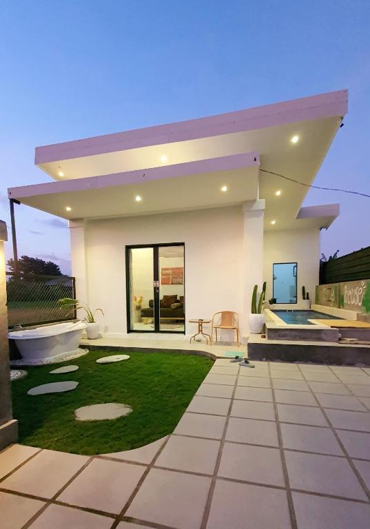 a small white house with a lawn in front of it at Villa Cozy Kapal 1BR private pool in Badung