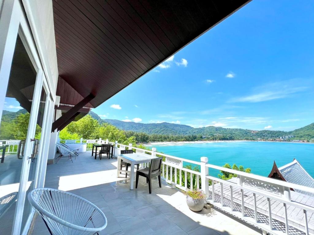 un balcon avec une table et des chaises et une vue sur l'eau dans l'établissement Jaokhun Bayview Kamala, Phuket, à Kamala Beach