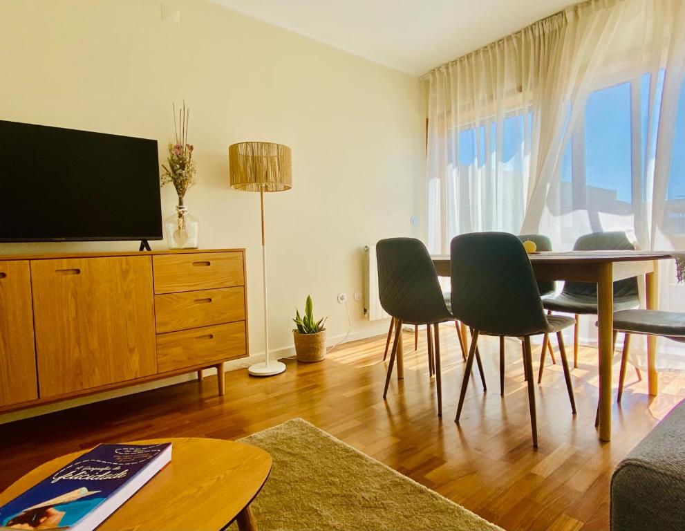 a living room with a table and chairs and a television at Serene Coastal Retreat with king Bed & Pool in Lavra in Lavra
