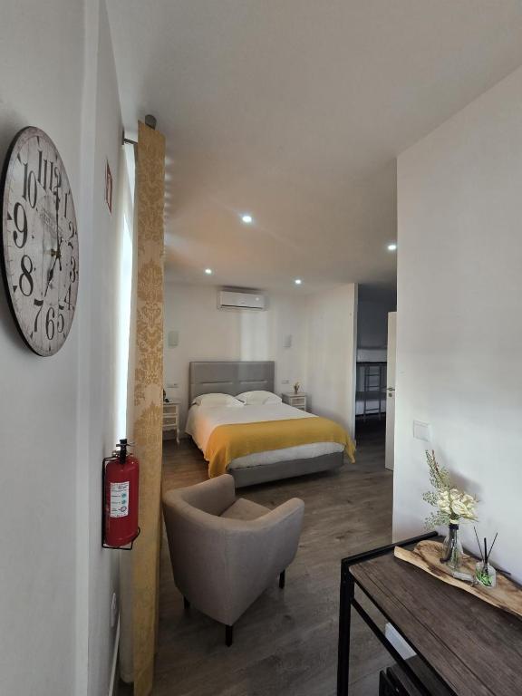 a bedroom with a bed and a clock on the wall at AquaChaves Apart Studios in Chaves