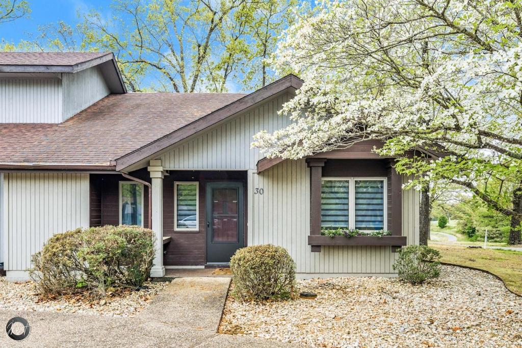 een huis met een bloeiende boom ervoor bij Modern 2BR Townhouse - Near Bike Trails & Golf in Dug Hill