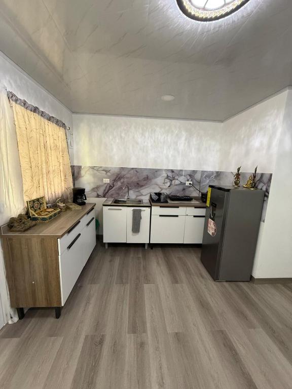a kitchen with white cabinets and a sink in a room at Casa taj beach house in La Loma