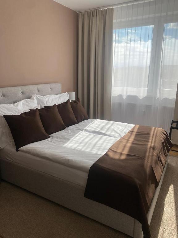 a large bed in a bedroom with a window at New Selina Byt in Levoča
